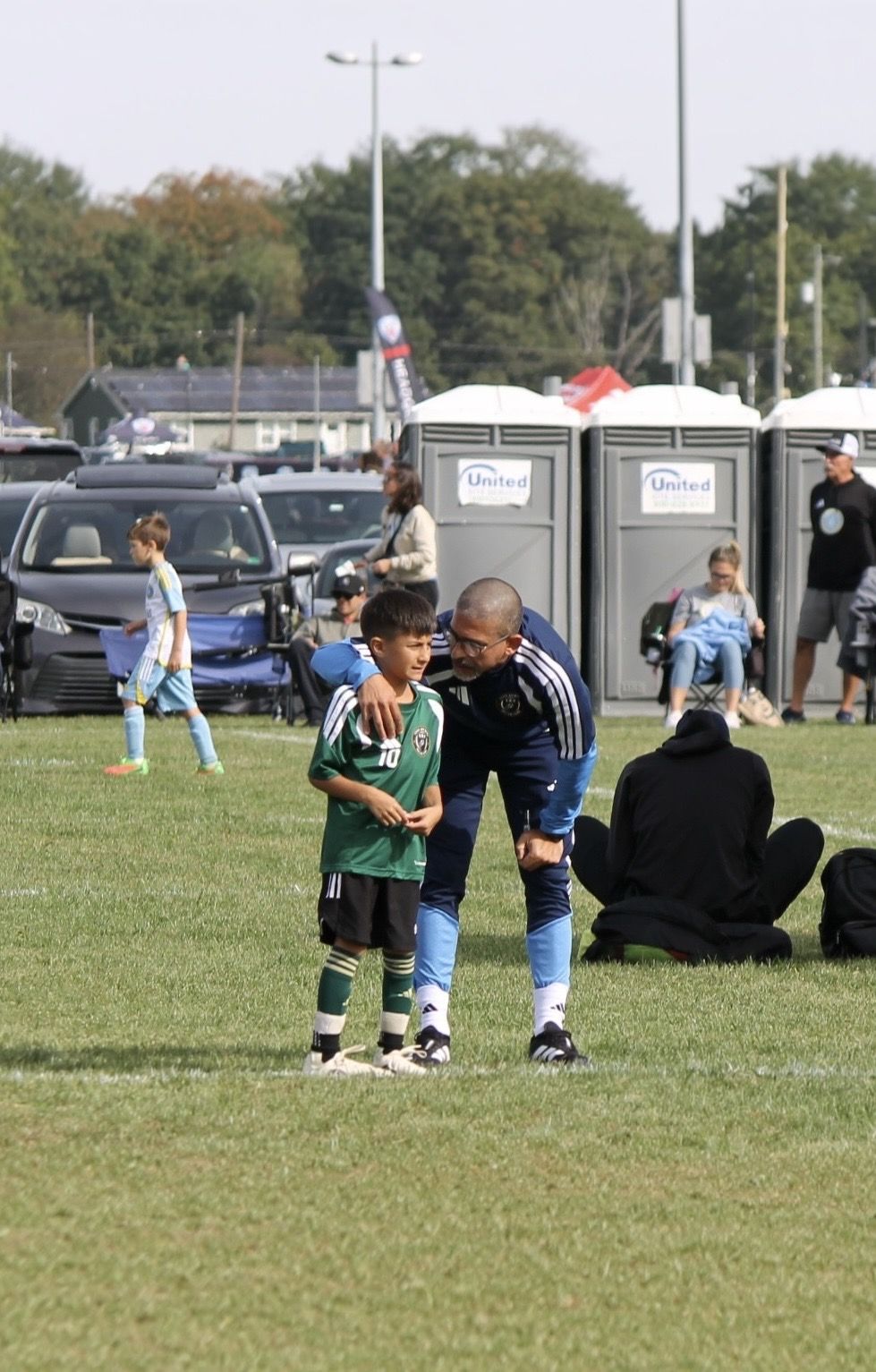 Coach Khaled talking with a U8 player during a game